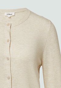 Beige gebreide cardigan met een ronde hals, kleine knopen aan de voorkant en geribbelde accenten bij de kraag en manchetten. Zachte textuur.