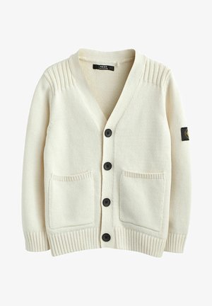 Cardigan en maille de couleur crème avec quatre boutons noirs, deux poches devant, des poignets côtelés et un patch noir sur la manche gauche.