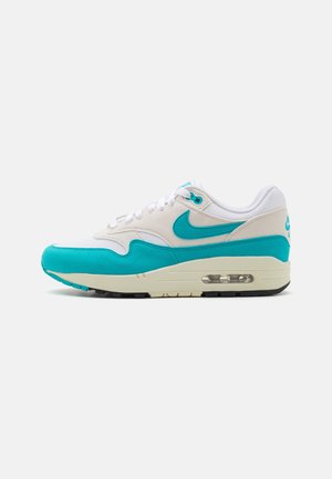 Białe i turkusowe sneakersy Nike Air Max z widoczną podeszwą z poduszką powietrzną, białymi sznurowadłami i turkusowym logo Nike po boku.