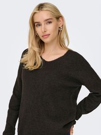 Tamni džemper s rebrastim uzorkom, izrezom u obliku slova V i dugim rukavima. Mekana tekstura, opušteni kroj, bočni prorezi i blago prevelik dizajn.