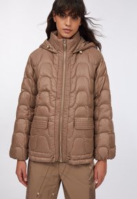 Giacca a piumino marrone trapuntata con colletto alto, chiusura con zip e due tasche frontali. Presenta coulisse all'orlo e una texture del tessuto lucida.