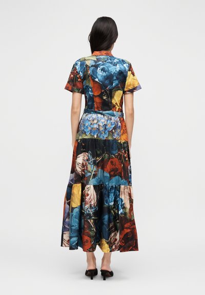 Lilleline maksikleit lühikeste varrukatega, millel on suurte mitmevärviliste lillede muster tumedal kangal, mitmekihiline seelik ja tihedalt istuv vöökoht.