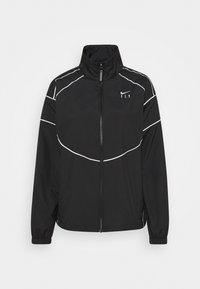 Chaqueta deportiva negra con cremallera, cuello alto y puños elásticos. Cuenta con líneas de acento blancas y un pequeño logo en el pecho.