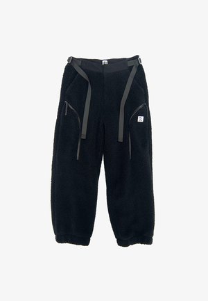 Czarne spodnie z polaru o fakturowej powierzchni, z dwoma bocznymi kieszeniami na zamek błyskawiczny i regulowanymi paskami w talii. Styl roboczy.