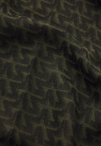 Textured fabric featuring a wavy zigzag pattern in dark green and black, showcasing a blend of colors and intricate weave details.