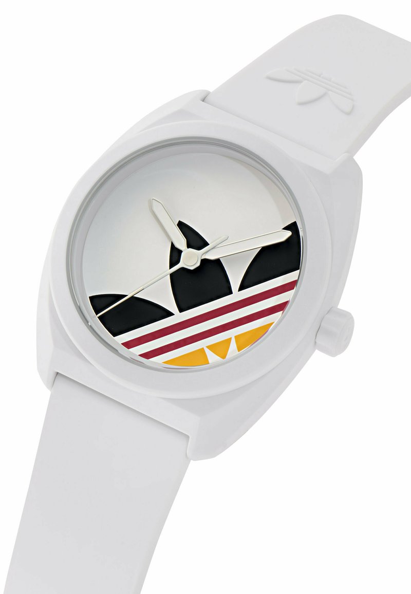 Reloj blanco de silicona con una esfera redonda que presenta elementos gráficos en negro, rojo y amarillo. Manecillas sencillas de hora y minuto con un diseño minimalista.