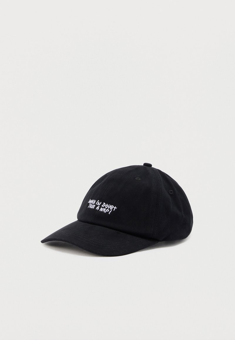 Μαύρο καπέλο μπέιζμπολ με λευκό κεντημένο κείμενο «When in doubt take a nap» στη μπροστινή πλευρά, παρουσιάζεται σε απλό φωτεινό φόντο.