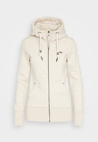 Sudadera con cremallera de color beige claro, con capucha ajustable por cordón, dos bolsillos frontales y puños de canalé. Textura suave con un patrón sutil en toda la prenda.