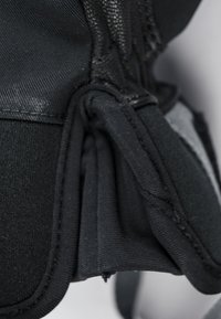 Schwarzer Stoff mit einer glatten, matten Oberfläche weist strukturierte Falten auf. Inklusive Nähdetails und scheinbar gepolsterten Bereichen zur Unterstützung.