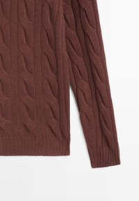 Bruine gebreide trui met een kabelpatroon, textuur met ribbelmanchetten en een ribgebreide zoom. De stof ziet er zacht en warm uit.