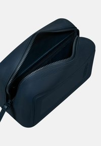 Borsa cosmetica rettangolare blu marino realizzata in silicone testurizzato, dotata di apertura a doppia cerniera e design durevole e flessibile.