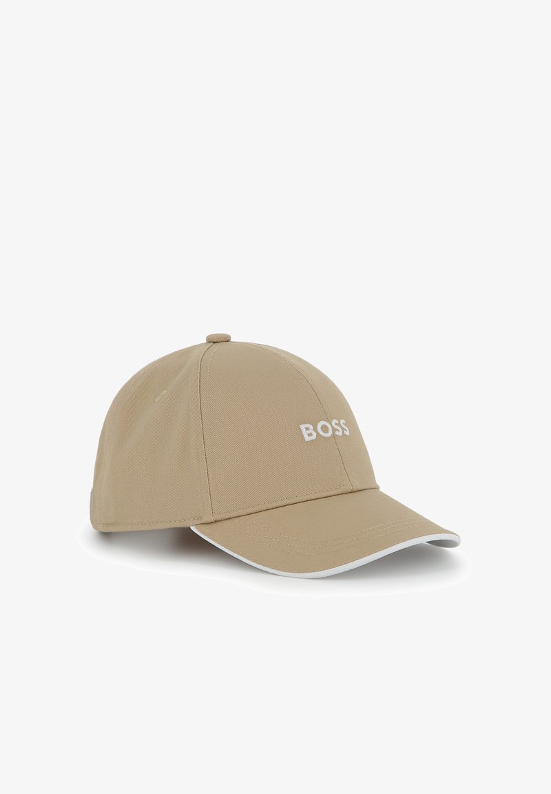 Casquette de baseball beige en tissu, avec une visière courbée, un logo "BOSS" blanc brodé sur le devant, et des coutures accentuées blanches.