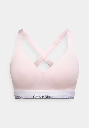 Rožinė braletė su V formos iškirpte, kryžminėmis nugaros petnešomis ir balta juosta su juodu užrašu „Calvin Klein“. Minkšta audinio tekstūra.
