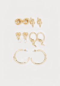 Ensemble de boucles d'oreilles dorées comprenant trois paires : clous d'oreilles noués, créoles et pendants ornés de perles, avec des designs et des finitions variés.