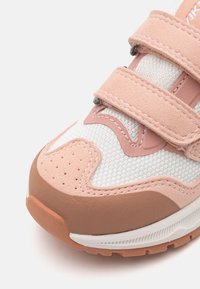 Sneaker med mesh-overdel i hvit og lyserosa semsket skinn, med to borrelåsremmer, avrundet tå og teksturert gummisåle.