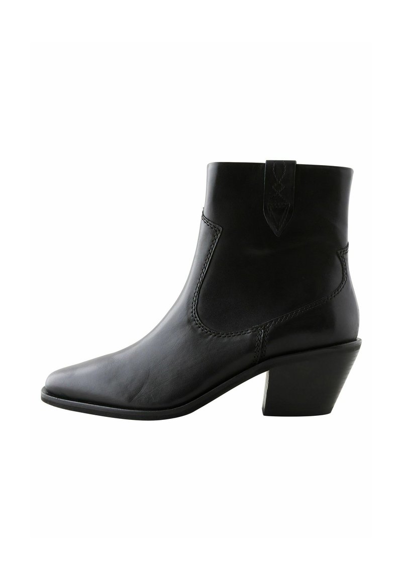 Bota de cuero negro hasta el tobillo con punta afilada, paneles elásticos laterales y tacón bloque. Textura suave con sutiles detalles de costura.