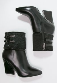 Botines de cuero negro hasta el tobillo con punta afilada, puño de lana texturizada y detalles brillantes en negro, que incluyen cremalleras y doble hebilla.