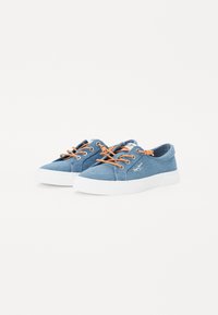 Ténis de denim com atacadores laranja, solas de borracha brancas e um logótipo cosido na lateral. Apresentam um design de cano baixo e tecido texturizado.