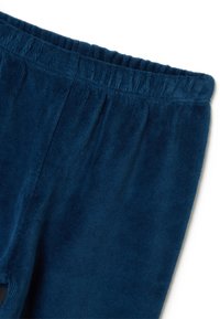Pantalon en velours bleu marine avec une finition texturée et douce. Il présente une taille élastique et une coupe décontractée avec des jambes droites.