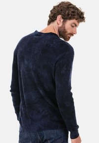 Marineblaues, geripptes Langarmshirt mit rundem Ausschnitt und strukturierter Stoffstruktur. Die Rückansicht zeigt eine weiche, entspannte Passform.
