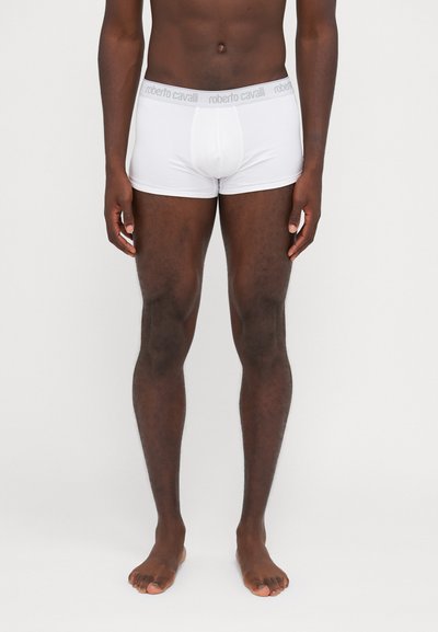 Boxer breifs blancos con una textura suave, que presentan una cinturilla elástica gris con el logo "roberto cavalli" impreso.