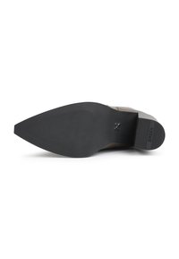 Semelle d'une chaussure de ville en cuir à bout pointu avec une semelle extérieure en caoutchouc noir texturé et des accents de talon et de semelle intermédiaire marqués.