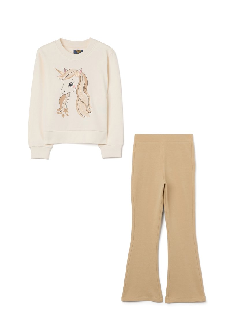 Felpa crema con grafica di un unicorno e dettagli dorati, abbinata a pantaloni beige a zampa d'elefante, entrambi realizzati in tessuto morbido.