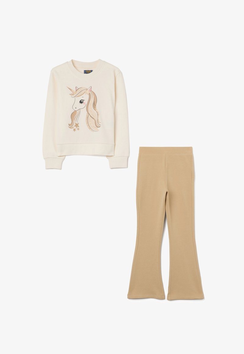 Felpa crema con grafica di un unicorno e dettagli dorati, abbinata a pantaloni beige a zampa d'elefante, entrambi realizzati in tessuto morbido.