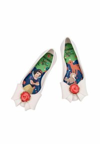 Bailarinas de goma blancas con un gran lazo y un acento de joya roja. Las plantillas muestran a Blancanieves y a animales del bosque sobre un fondo verde.