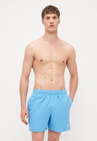 Shorts de bain bleu clair en tissu doux et élastique, avec une taille élastique et des poches latérales. Présente un petit logo blanc sur le devant.