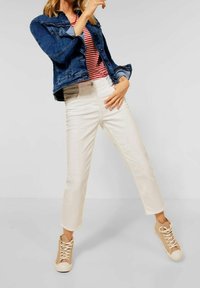 Denim jacket, dark blue, buttoned, with front pockets. Striped red and white T-shirt. White cropped jeans, tan high-top sneakers.