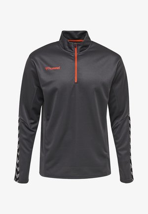 Pull-over à zip quart en tissu gris foncé avec surface texturée ; présente une fermeture éclair orange et un logo, ainsi qu'un motif en chevron noir et blanc sur les manches.
