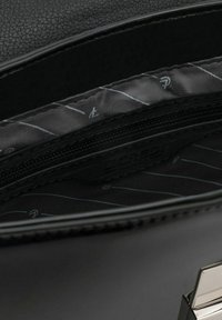 Schwarze Kunstledertasche mit einem Innenraum, der eine Reißverschlusstasche enthält. Der Innenstoff ist weich und hat ein diagonales Streifenmuster in Grau.