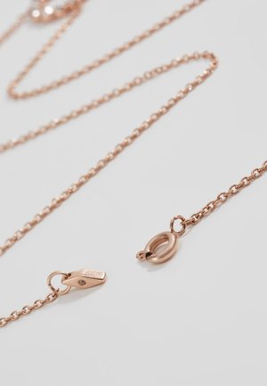 Collier délicat en chaîne or rose avec un petit fermoir ressort ovale ouvert, posé sur une surface gris clair.