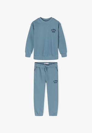 Ensemble sweatshirt et joggers bleu clair en tissu doux. Le sweatshirt a un col rond et un détail de logo ; les joggers possèdent une taille élastique.