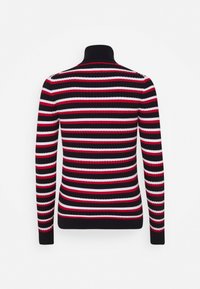 Pull à col roulé rayé noir, rouge et blanc ; texture côtelée ; manches longues ; design ajusté.