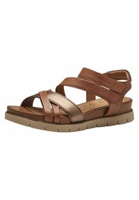 Sandales en cuir marron avec de larges brides croisées, des accents métalliques et une semelle intérieure rembourrée. La semelle présente un design de grip texturé.