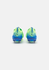 Le scarpe da calcio presentano una parte superiore giallo-verde vivace con accenti blu testurizzati, una suola blu stampata e tacchetti metallici per la trazione.