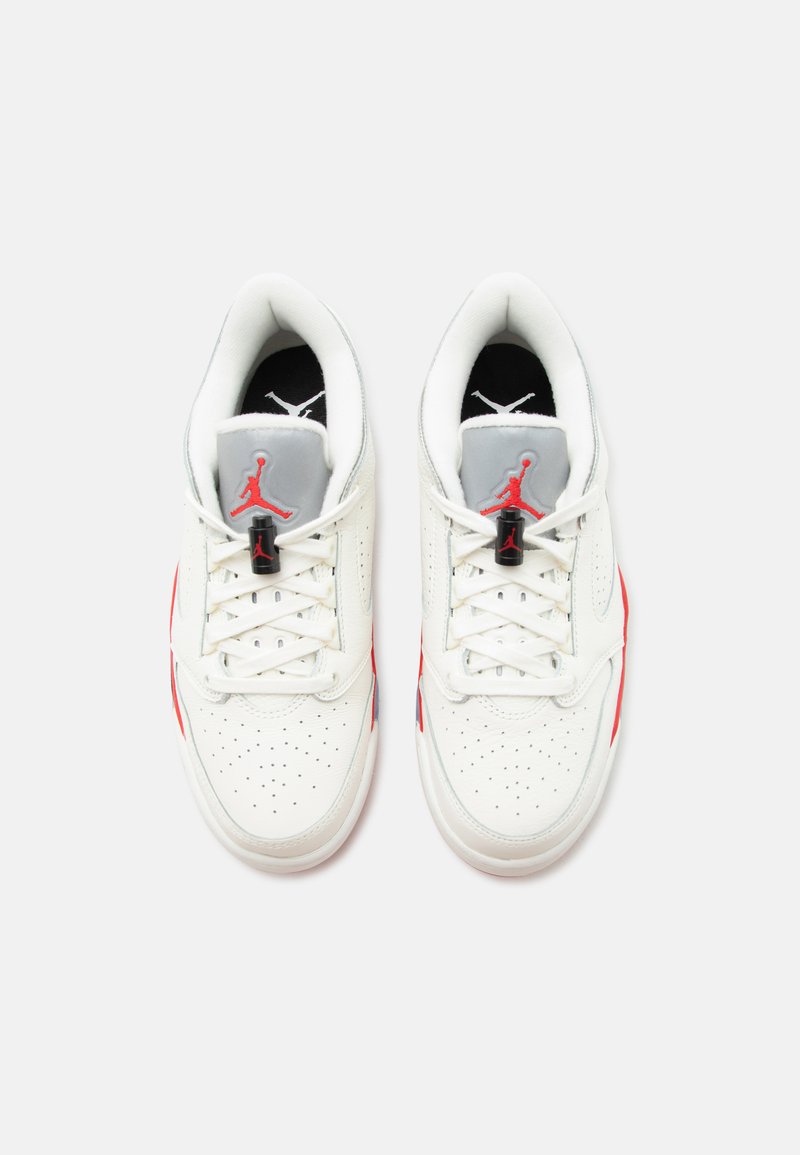 Par de zapatillas blancas Air Jordan con logo Jumpman rojo en la lengüeta gris, cordones blancos y puntera perforada vistas desde arriba.