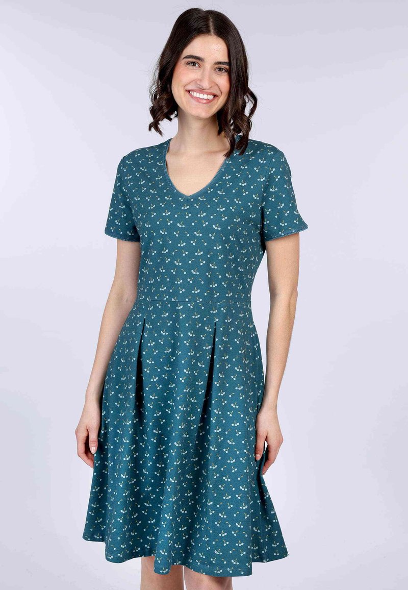 Türkisfarbenes Kleid mit kurzen Ärmeln und V-Ausschnitt. Es hat einen weiten Rock mit Falten und ein Blumenmuster aus kleinen grünen und weißen Blumen.