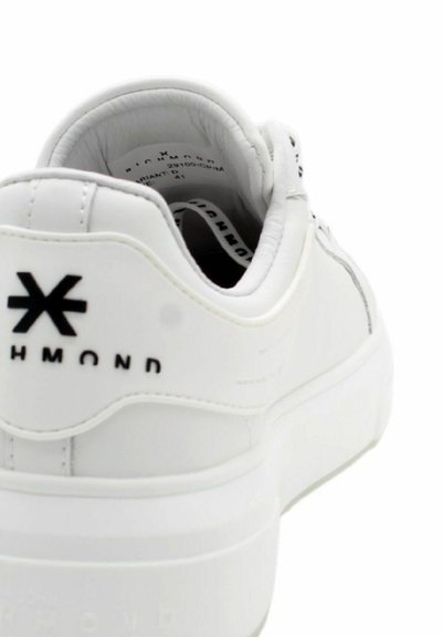 Sneaker bianco con tomaia in pelle liscia, design arrotondato, suola bianca e logo nero a contrasto sul tallone. Interno morbido.