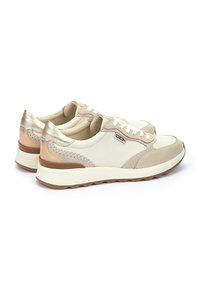Zapatillas de cuero beige con acentos metálicos dorados, costuras texturizadas, cordones blancos y una suela de goma gruesa y en contraste.