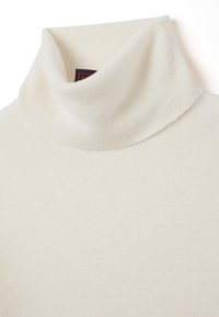 Jersey de cuello alto de color crema, hecho de un tejido de punto suave, con una textura acanalada y un diseño de collar doblado.