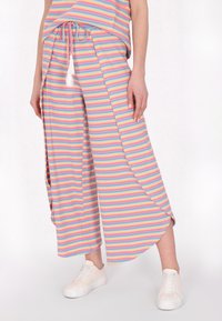 Gestreepte, pastelgekleurde wijde broek met een trekkoord in de taille en zijsplitten. Gemaakt van een zachte, ribbelstof. In combinatie met witte sneakers.