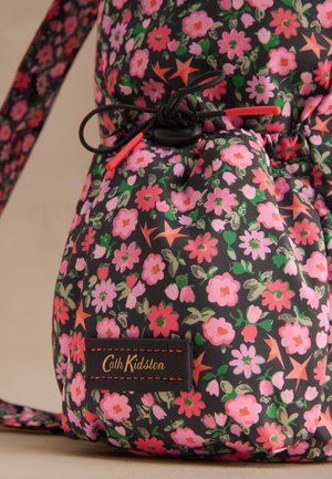 Geantă din material textil cu snur, cu model floral în nuanțe de roz, roșu și verde pe fundal negru, având o etichetă cu sigla Cath Kidston.
