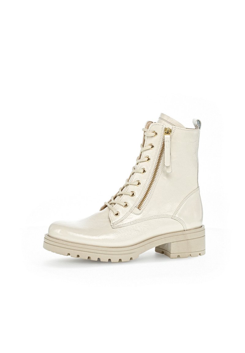 Beige lederen enkellaars met vetersluiting aan de voorkant, zijrits, textuur op het oppervlak en een blokhak. Voorzien van goudkleurige hardware en een gladde afwerking.