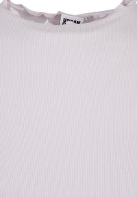 Vitt ribbat linne med en scalloped halsringning. Tyget är mjukt med en texturerad yta. Lappen säger "URBAN".