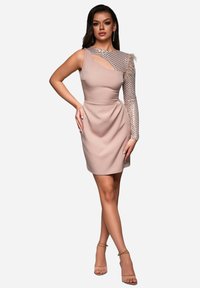 Asymmetrische blush jurk met één korte mouw en een mesh detail. Fittend silhouet met gedrapeerde stof en een uitsnijding op de schouder.
