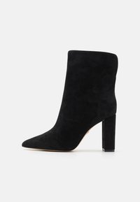 Juodos suedes kulkšnies botai su smailiu nosiu ir storu blokiniu kulnu. Lygus paviršius be matomų raštų ar metalinių detalių.