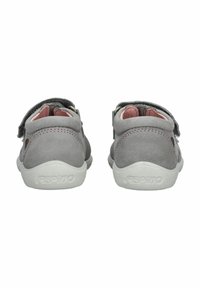 Šedé semišové dětské boty s růžovými akcenty a nastavitelnými suchými zipy. Mají bílou gumovou podrážku a polstrovaný límec pro pohodlí.